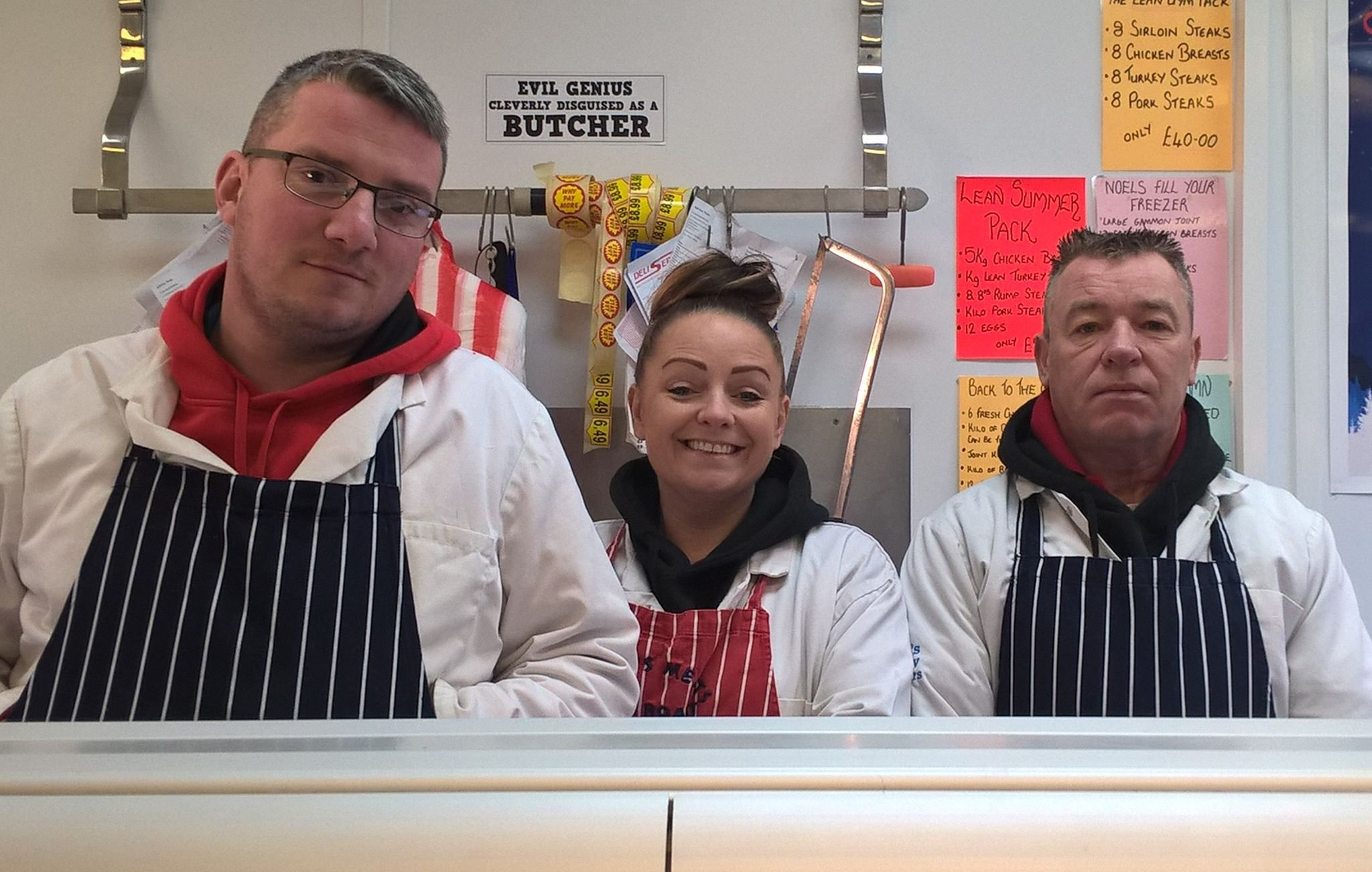 Three of the Noels team in whites and navy striped aprons behind the counter
